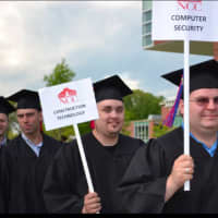 <p>Norwalk Community College graduates display signs with the names of the degrees they received.</p>