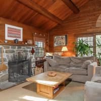 <p>The log cabin structure has a beautiful stone fireplace.</p>