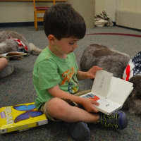 <p>James Corcoran, 4, of Stratford reads to Drago the therapy dog at Stratford Public Library.</p>