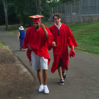 <p>Greenwich High School graduates, Keanu Meza, left, and Max Stallings, right, hurry to join their fellow classmates shorty before the 147th commencement started Tuesday evening.</p>