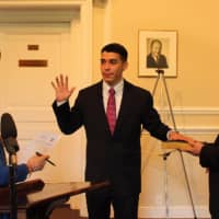 <p>Rye&#x27;s newest police officer, Christopher Salguero, a former New York State Park Police officer, takes the oath of office from Deputy City Clerk Diane Moore at City Hall. His father, Carlos Salguero, looks on.</p>