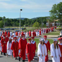 <p>A long line of Somers High School graduates marches toward the 2016 commencement.</p>