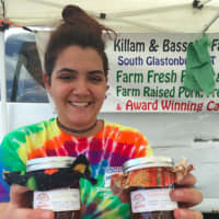 <p>Valentina Pinzon holding a couple of bottles of Killiam &amp; Bassette Farmstead jams at the Danbury Farmers Market on Saturday. The business is in South Glastonbury. The market opened Saturday and runs until Oct. 22.</p>