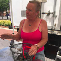 <p>Laurie Popadic explains how to cook little neck clams to a customer at the Danbury Farmers Market. The market opened Saturday and continues until Oct. 22.</p>