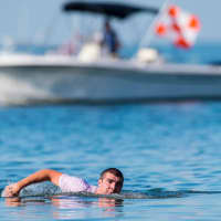 <p>A swimmer pops out of the water momentarily to take a breath during the Swim Across America Greenwich-Stamford.</p>
