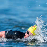<p>A swimmer splashes through water at the event.</p>