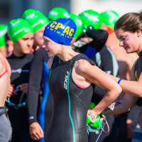 <p>A swimmer for the Chelsea Piers Connecticut team gets help with her wetsuit before the swim.</p>