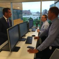 <p>Gov. Dannel P. Malloy speaks with security operation center analysts Albert Straniti, center, and Jeriel Udom, right, at the official opening of CYBERshark in Stamford.</p>