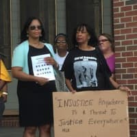 <p>Two women holding signs at a Norwalk NAACP rally Tuesday night. It was called after the recent shooting deaths of two black men and five police officers.</p>