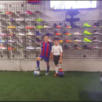 <p>The Vazquez&#x27; nephews, from left, Ricardo and Bryan Rodriguez, stand beside shoes in the store.</p>
