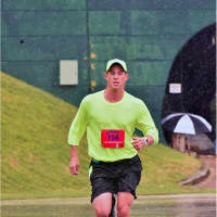 <p>Bethel resident Chris Longo running down final stretch of his 8th marathon on the historical Lake Placid Olympic oval in the pouring rain on June 12.</p>