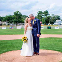 <p>Jenn and Dan Balliett, a Norwalk couple, kiss on the pitching mound where they first met at Broad River Park. The couple married on July 16.</p>