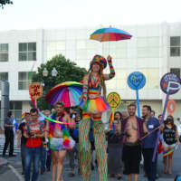 <p>Stilt walker Lady Blaze leads the Pride Walk through downtown Bridgeport at the opening of the SameSex exhibition at City Lights Gallery.</p>