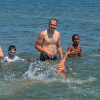 <p>New swimmers compete in a friendly relay race through at Seaside Park Friday while instructors in the Horizon program cheer them on.</p>