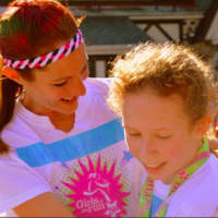 <p>Ramsey Girls on the Run coach Maggie Ford embraces an athlete following the May 5K race in Sparta.</p>