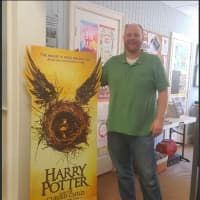 <p>Steve Hutchinson of Byrd&#x27;s Books in Bethel, poses by the poster for Harry Potter&#x27;s newest book -- &quot;Harry Potter and the Cursed Child -- Parts I &amp; II.&quot; The newest book is releasing on July 31.</p>
