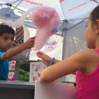<p>A young volunteer distributes cotton candy.</p>