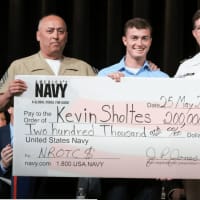 <p>Kevin Sholtes, center, with Master Sergeant Joseph Meehan, left, and Lieutenant Commander Mark Dwinells, holds up a scholarship check. Sholtes will join the Navy ROTC program at Ohio State.</p>