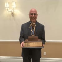 <p>Bergen Catholic wrestling coach Dave Bell holding the Group III, IV &amp; V County Championship trophy.</p>