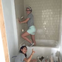 <p>Girls work on tiling for a bathroom at one of the homes on the reservation.</p>