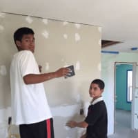 <p>Boys from Round Hill Community Church in Greenwich help with the construction of a wall in a home on the reservation.</p>