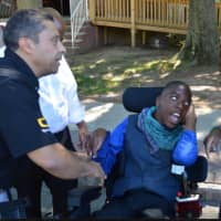 <p>A Quantum Rehab official presents Courtney, 14 of Leonia, with his new specialized replacement wheelchair with his mother.</p>