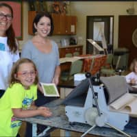<p>DAC’s Visual Arts Director Beth Cherico and Visual Arts Instructor Jill Sarver help young guests with a printmaking project in the DAC Visual Arts Studio.</p>