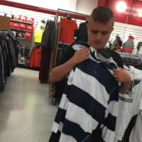 <p>Tyler Banuls tries a shirt for size at TJ Maxx in Lyndhurst.</p>