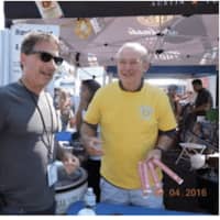 <p>Two Sunrise Rotarians, Library Executive Director Bill Harmer and Phil Sharlack. Phil holding ID bracelets for people buying alcohol.</p>