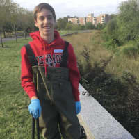 <p>Colin Glascott, from Bedford Hills, N.Y., a 10th grade student at the Harvey School in Katonah, N.Y., getting ready to wade into the water as part of a cleanup at Mill River Park in Stamford on Tuesday.</p>