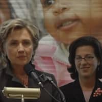 <p>Lindsay Farrell, right, listens as Hillary Clinton speaks during a visit to Open Door.</p>