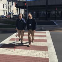 <p>Phil Magalnick, left, a Stamford resident who is legally blind, and state official John Waiculonis walk across the new Z-shaped crosswalk on Washington Boulevard near the Government Center.</p>