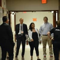 <p>New Castle Police meet with Chappaqua school board members in a hallway after the board halted its meeting. The meeting was halted due to interruptions from local critic Will Wedge.</p>