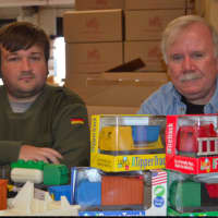 <p>Luke and his father Jim Barber with some of the trucks they make</p>