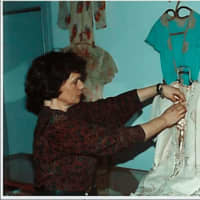 <p>New Canaan Historical Society Executive Director Janet Lindstrom puts finishing touches on a costume exhibit.</p>