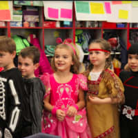 <p>Kindergartners, from left, Connor Gonnella, John Hall, Ellery Kraus, Lily Ryan and Jace Tamaye get ready to head outside for the Holmes School annual Halloween parade.</p>