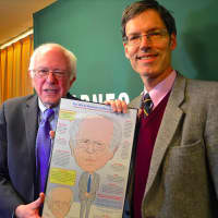 <p>Bob Carley presenting Bernie Sanders with a caricature.</p>