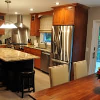 <p>Denise Wenacur and her team completely renovated this kitchen, and finished the project with cherry wood custom cabinetry, glass backsplash tile, oversized brick patterned porcelain floor tile and breathtaking granite.</p>