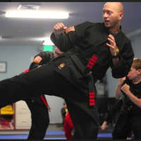 <p>Michael Nahan, owner of Kempo Academy of Darien, practicing kicks with his students</p>