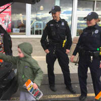 <p>Eamon Gorman, 4, from Norwalk, contributes toys during the Norwalk Police Department&#x27;s Stuff A Cruiser event at Toys &#x27;R Us. Looking on are officers Keith Torreso and Sara Laudano.</p>