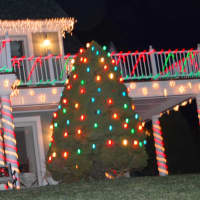<p>A lit-up Christmas tree is on the side of the 6,000-square-foot home of Wilton resident Walter Schalk.</p>
