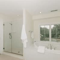 <p>The master bathroom features a hot tub and luxury shower, overlooking the backyard and pool.</p>