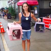 <p>Volunteer Kristi Heller poses with two dogs brought to Saint Rocco&#x27;s Feast in Fort Lee.</p>
