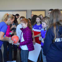 <p>Kristine Lilly signs soccer balls and gives autographs to kids after her talk.</p>