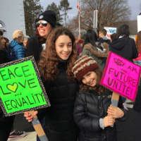 <p>Sophie, left, and Maddy Schwartz from Glen Rock hold signs promoting peace, love and unity.</p>