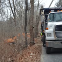 <p>Crews work on cleanup Tuesday after a truck crash caused nearly 2,000 gallons of oil to spill onto Judd Road in Monroe near the Easton border on Monday.</p>