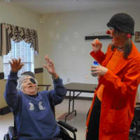 <p>Spark Arts owner, Cynthia Rauschert, dressed as a clown, working with seniors.</p>