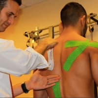 <p>A Cliffside Park sports chiropractor uses tape to realign Saenz&#x27; shoulders.</p>