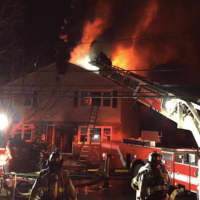 <p>Greenwich firefighters using the ladder truck to fight the fire at 63 Riverdale Ave., early Friday morning.</p>