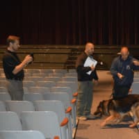 <p>A K-9 team searches for potential explosives in the auditorium at Staples High School.</p>